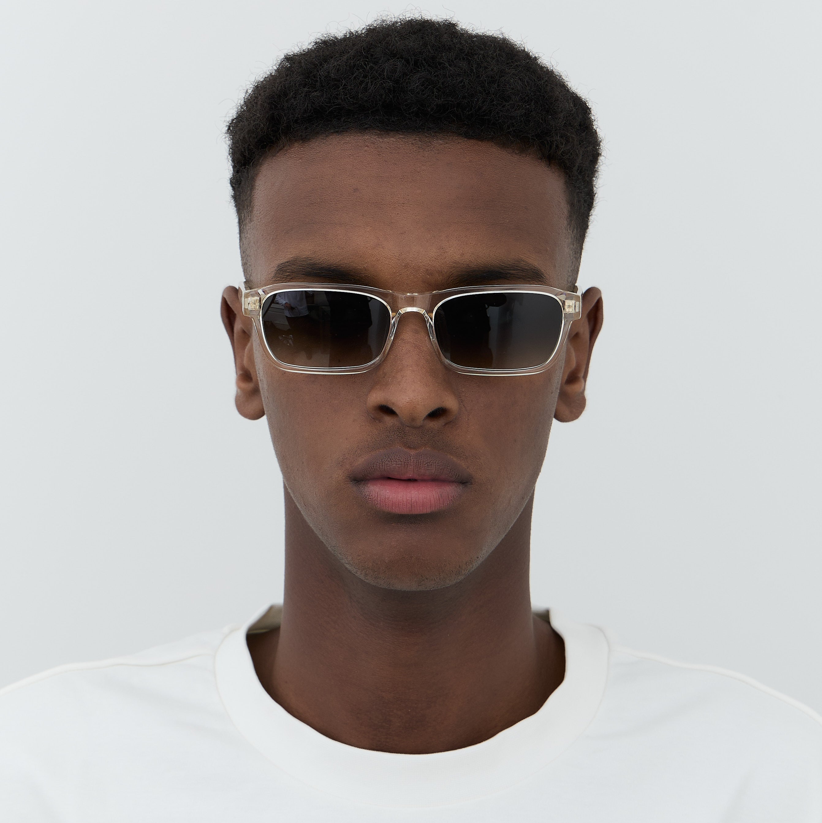 Model wearing transparent acetate sunglasses with green lenses.