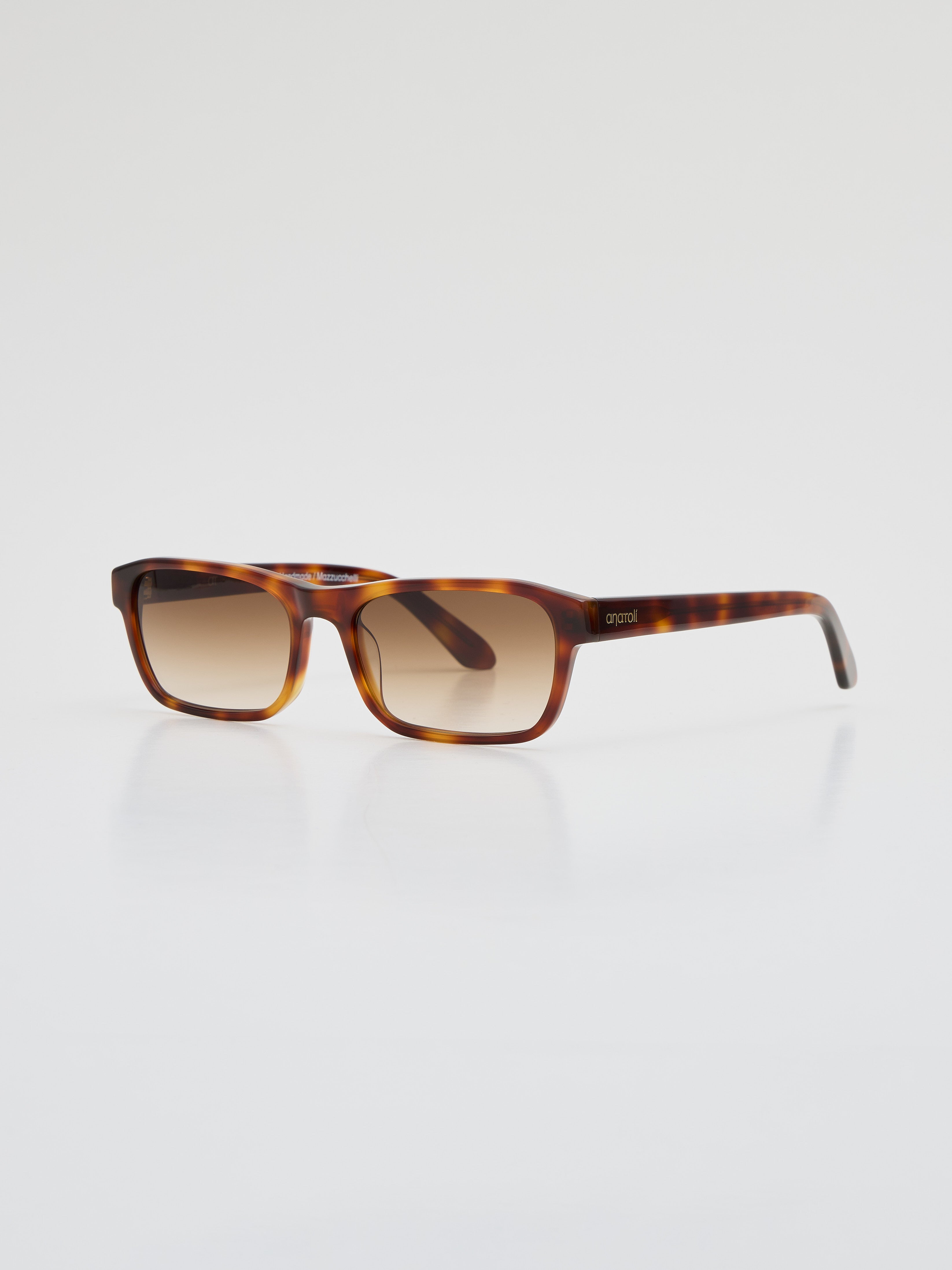 Angled side view of Latiner sunglasses in tortoiseshell Mazzucchelli acetate with brown gradient Carl Zeiss lenses, showing engraved Anatolí logo on the temple.
